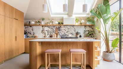 Sage green kitchen cupboard with glass doors containing kitchen essentials