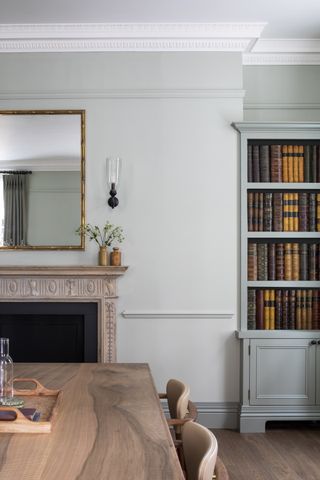 A office area with a large fireplace and blue bookcase