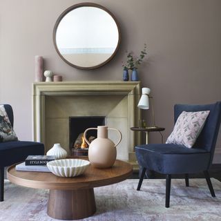 living room with round mirror fireplace and armchairs