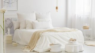 a bedroom with white bedsheets and white decor
