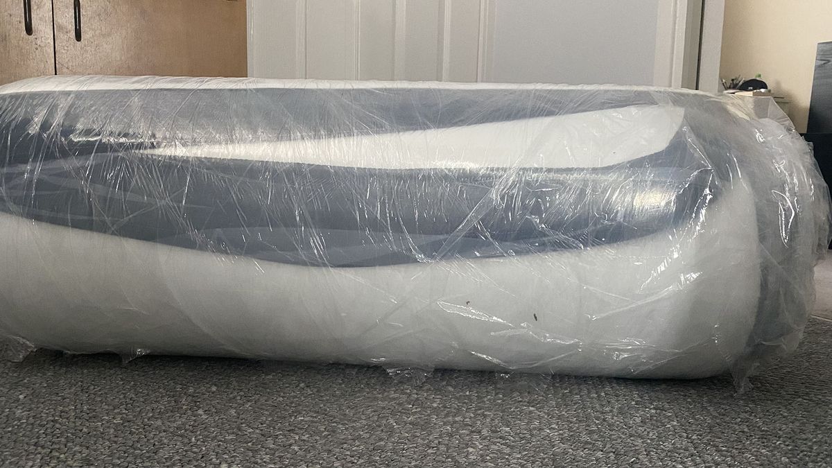 The Plank Firm Mattress compressed and rolled in plastic, in the reviewer's home