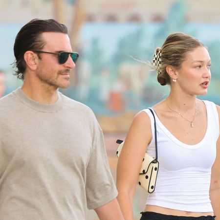 Gigi Hadid walking with Bradley Cooper in Paris. Gigi wore a white tank top with a black lace-trimmed midi skirt and black leather flip-flops. She carried a polka-dot Valentino Garavani DeVain bag