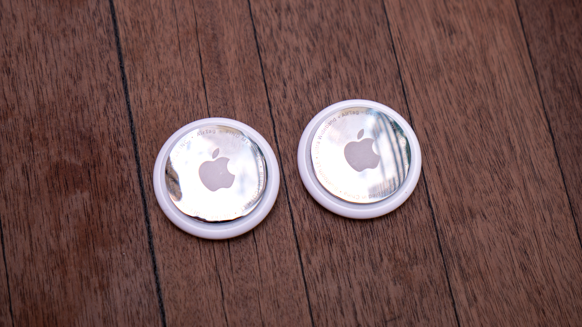 Apple AirTag 2 and AirTag 1 next to each other.