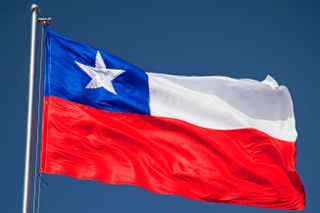 The flag of Chile on a flagpole against a blue sky