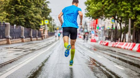 A runner trudges toward the finish line of a long and rainy race.