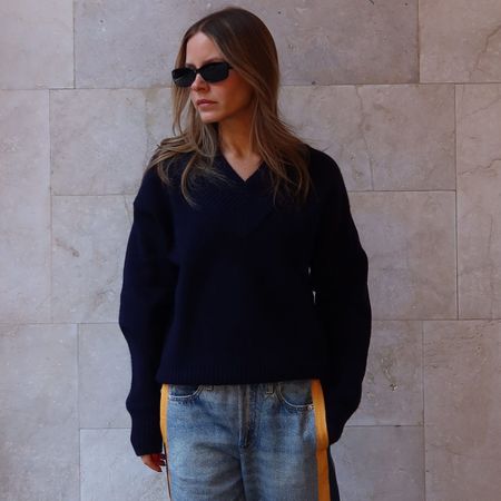 Nikki wears a navy sweater and miramar sport pants.