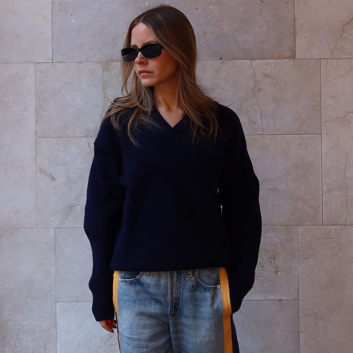 Nikki wears a navy sweater and miramar sport pants.