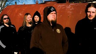 Meshuggah standing outside a brick building in 2008