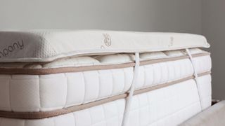 Best Saatva mattress sales: An image of a Saatva Graphite Mattress Topper fastened on top of a Saatva bed