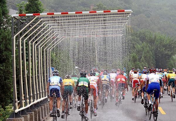 Wet patch: Riders pass through the showers that were set up to keep body temperatures cool.