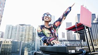 Female DJ points her hand to the sky during an outdoor set