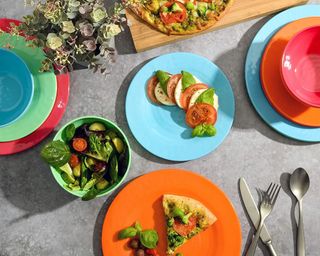 Colorful tableware on outdoor table, food plated up