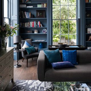 living room with blue blood paint sofa cushions and armchair
