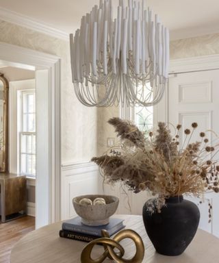 entryway with neutral decor and statement pendant light