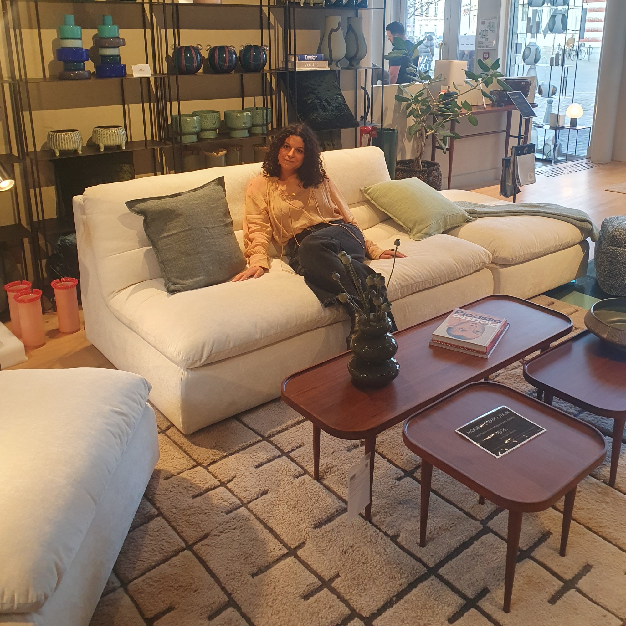 Sara sitting on a white modular sofa at La Redoute's AM.PM store in Lille, France
