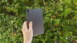 Xiaomi Pad Mini, rear panel visible, greenery in background