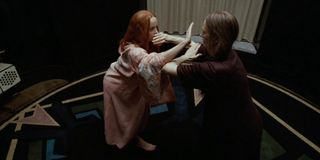 Suspiria Dakota Johnson and Tilda Swinton dancing with hands and arms locked