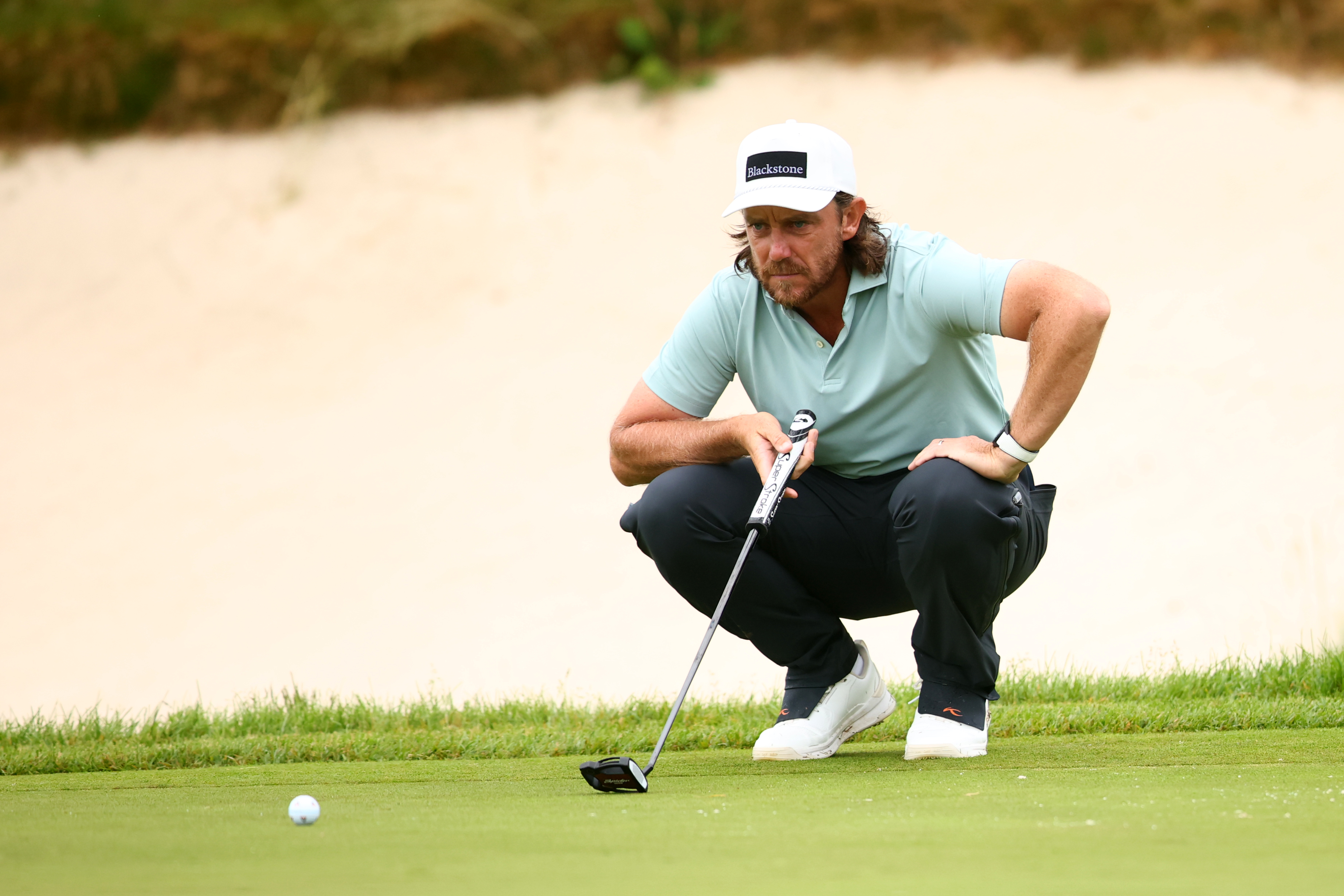 Tommy Fleetwood reading a putt on the green