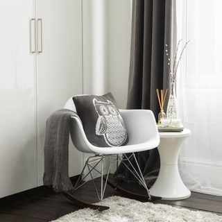 room with white rocking chair and curtain
