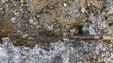 Archaeologists used warm water to melt the ice and snow around this Iron Age arrow found in Norway.