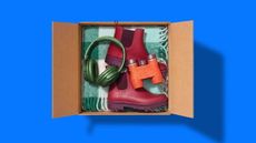 A shipping box filled with assorted products, including headphones, binoculars and boots.