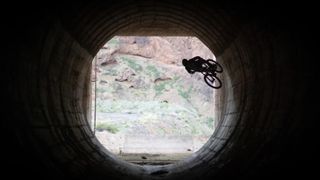 Sam Pilgrim riding his mountain bike in a tunnel
