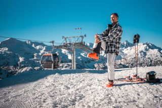 A skier stretching on the top of the mountain