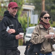 Lily wears a khaki jacket and chanel bag with her husband Charlie McDowell.