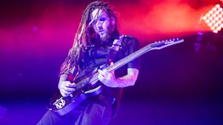 Best 7-string guitars: Korn playing live with a 7-string guitar