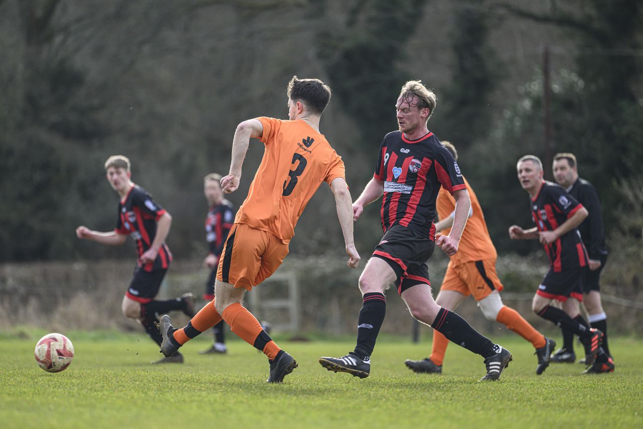 Some footballers playing in a field
