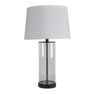 A black clear glass lamp base with a white shade