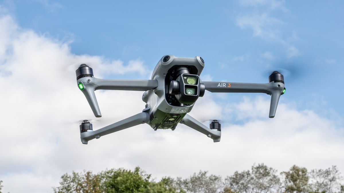 DJI Air 3 drone hovering against a blue sky