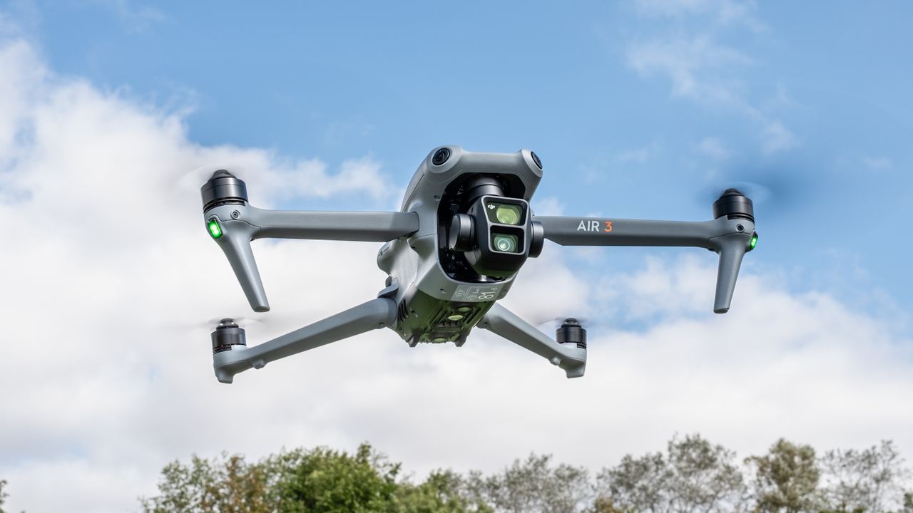 DJI Air 3 drone hovering against a blue sky
