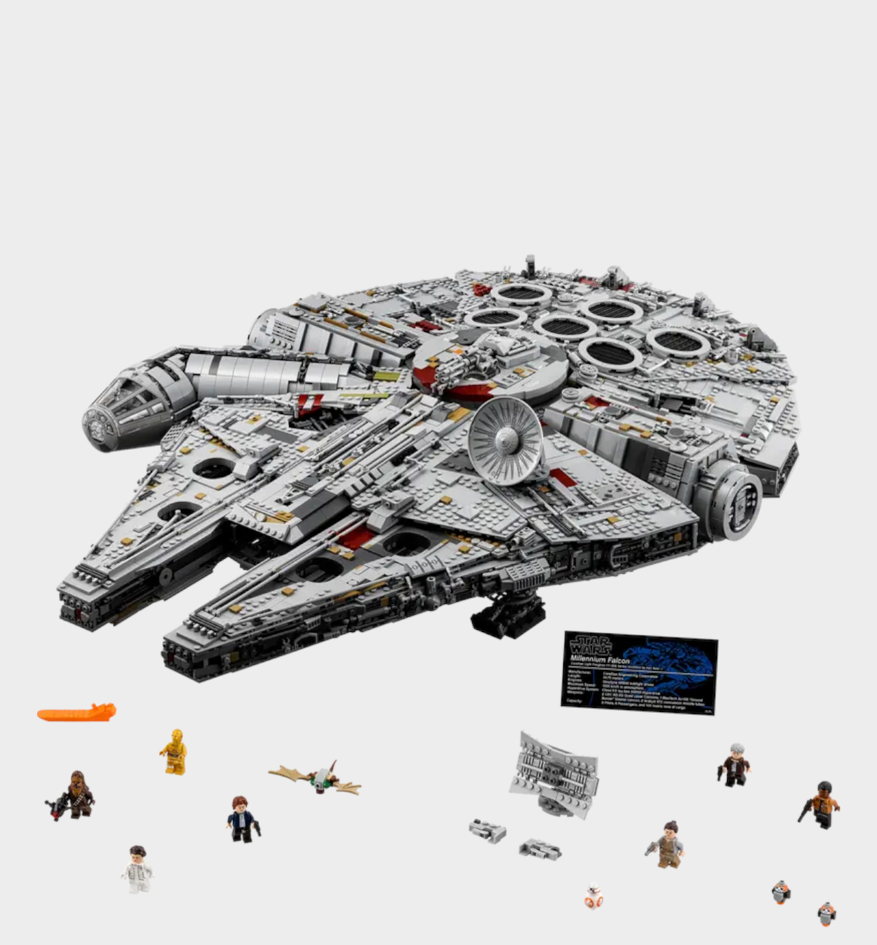 Lego UCS Millennium Falcon, plaque, and minifigures on a plain background