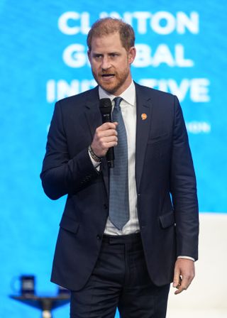 Prince Harry speaking at the Clinton Global Initiative in a suit and tie