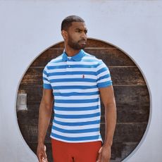 Male model wearing a blue striped polo and red bottoms sold at Mainline Menswear