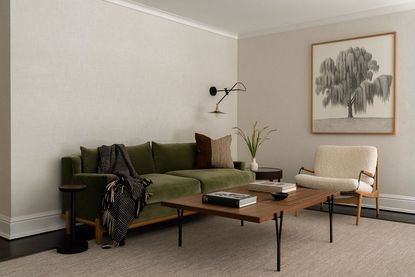 modern living room with beige walls and green velvet sofa