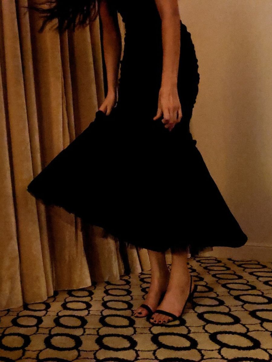 Kendall Jenner wearing a black dress and heels with a black pedicure