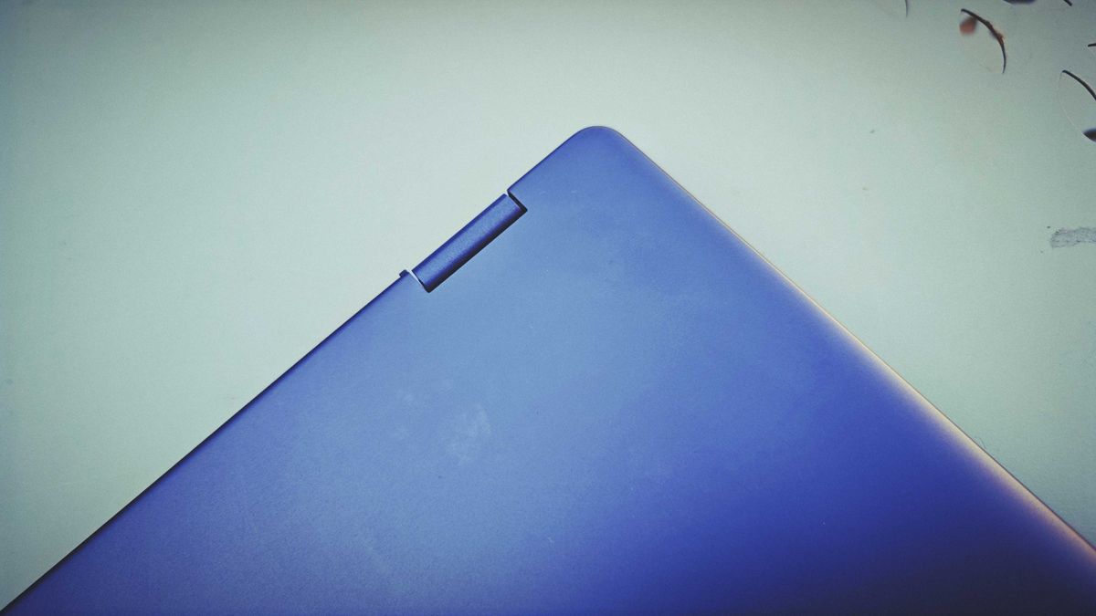 A Dell 16 Plus 2-in-1 laptop on a blue garden table