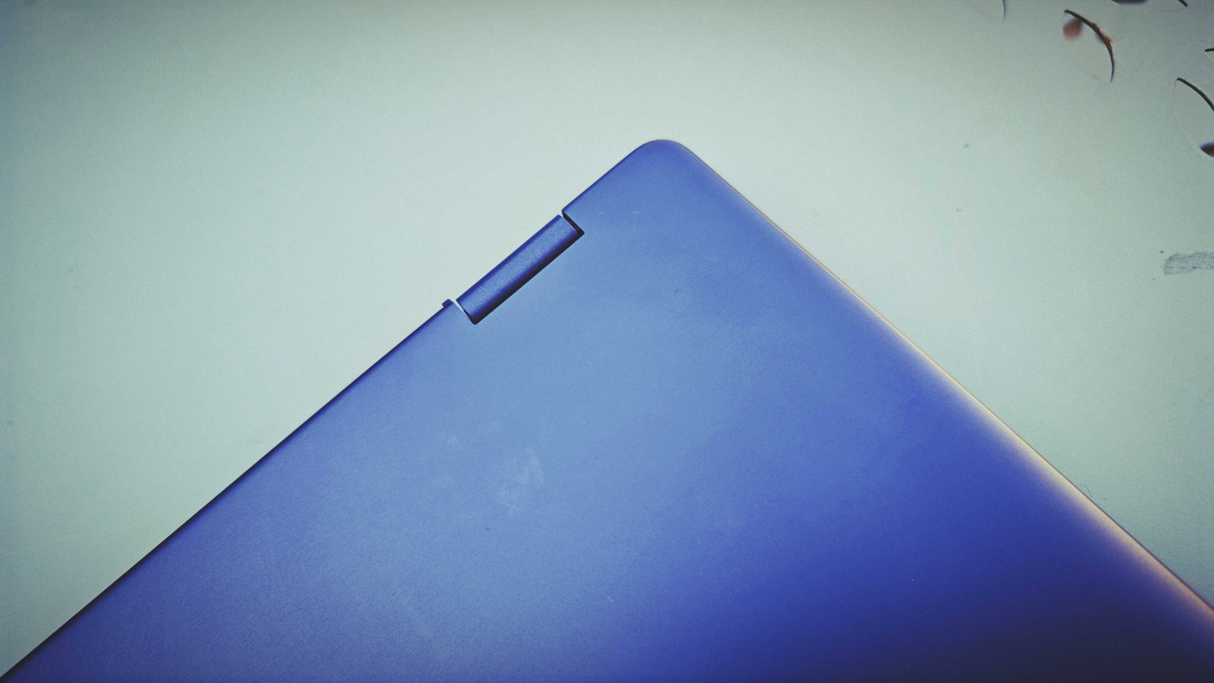 A Dell 16 Plus 2-in-1 laptop on a blue garden table
