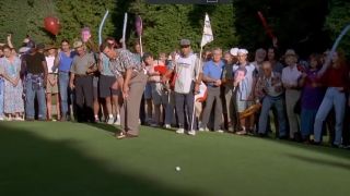 Christopher McDonald putting on a green with a huge crowd behind him.