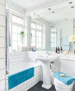 bathroom with white tiles on wall sink and mirror
