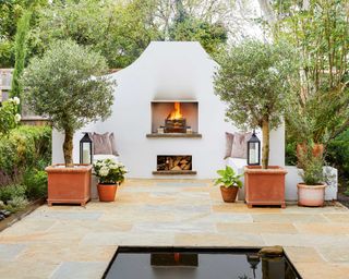 greek style garden with fireplace and olive trees