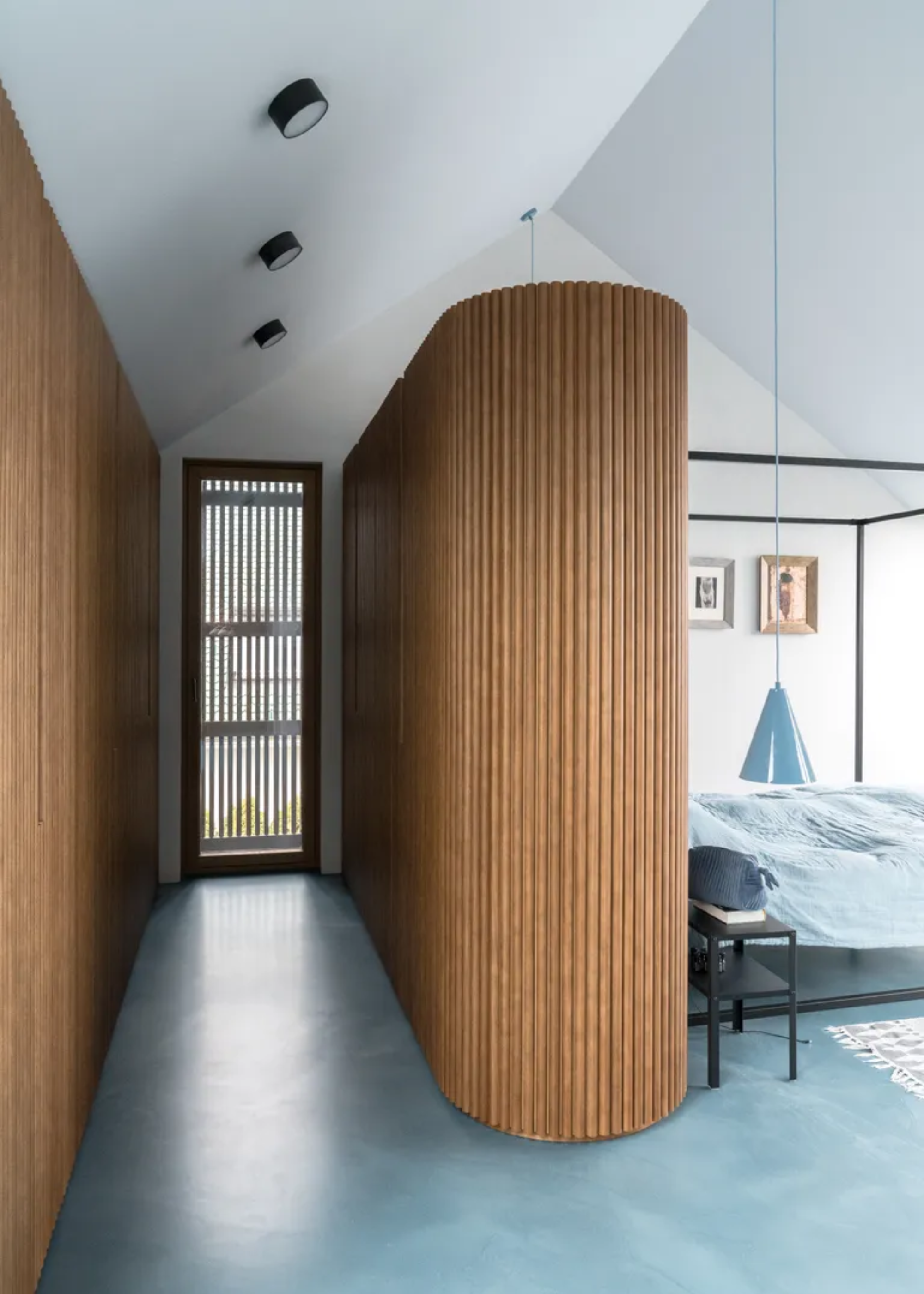 A wood panelled wardrobe in a light blue bedroom