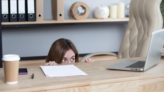 office worker hiding scared