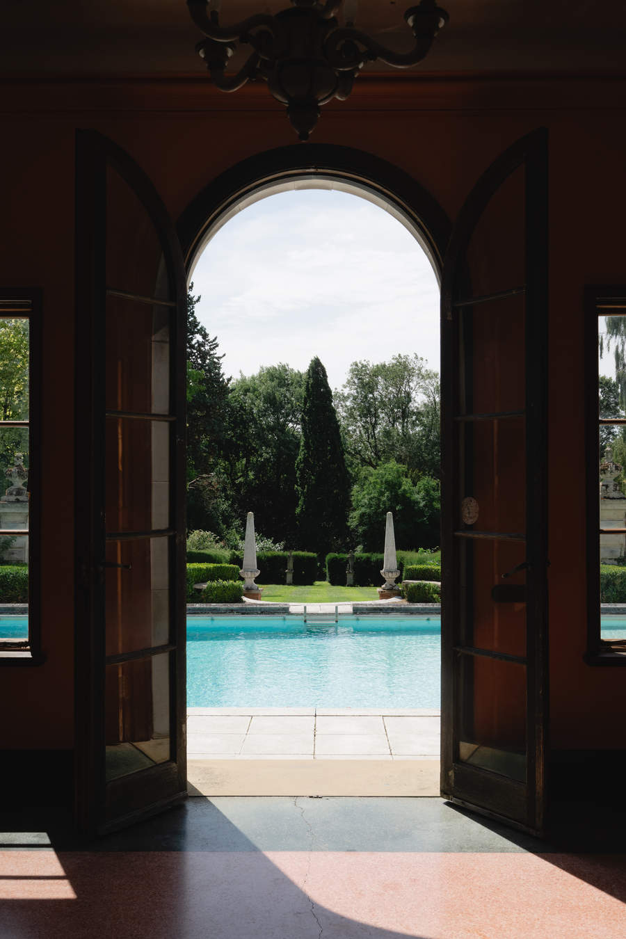 View through an arched doorway onto a swimming pool in Essex.