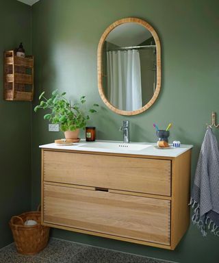 Small green bathroom with mirror and wooden vaniety