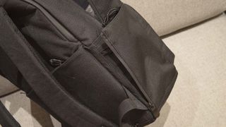 A Lo & Sons Hanover Deluxe 2 backpack laying on its side on a gray couch