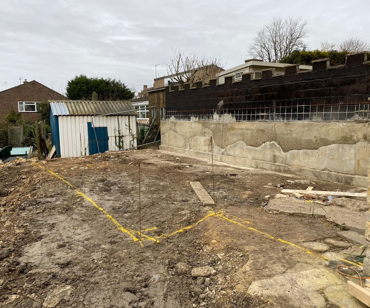 Shot of a demolished outbuilding with ground being marked out for an extension