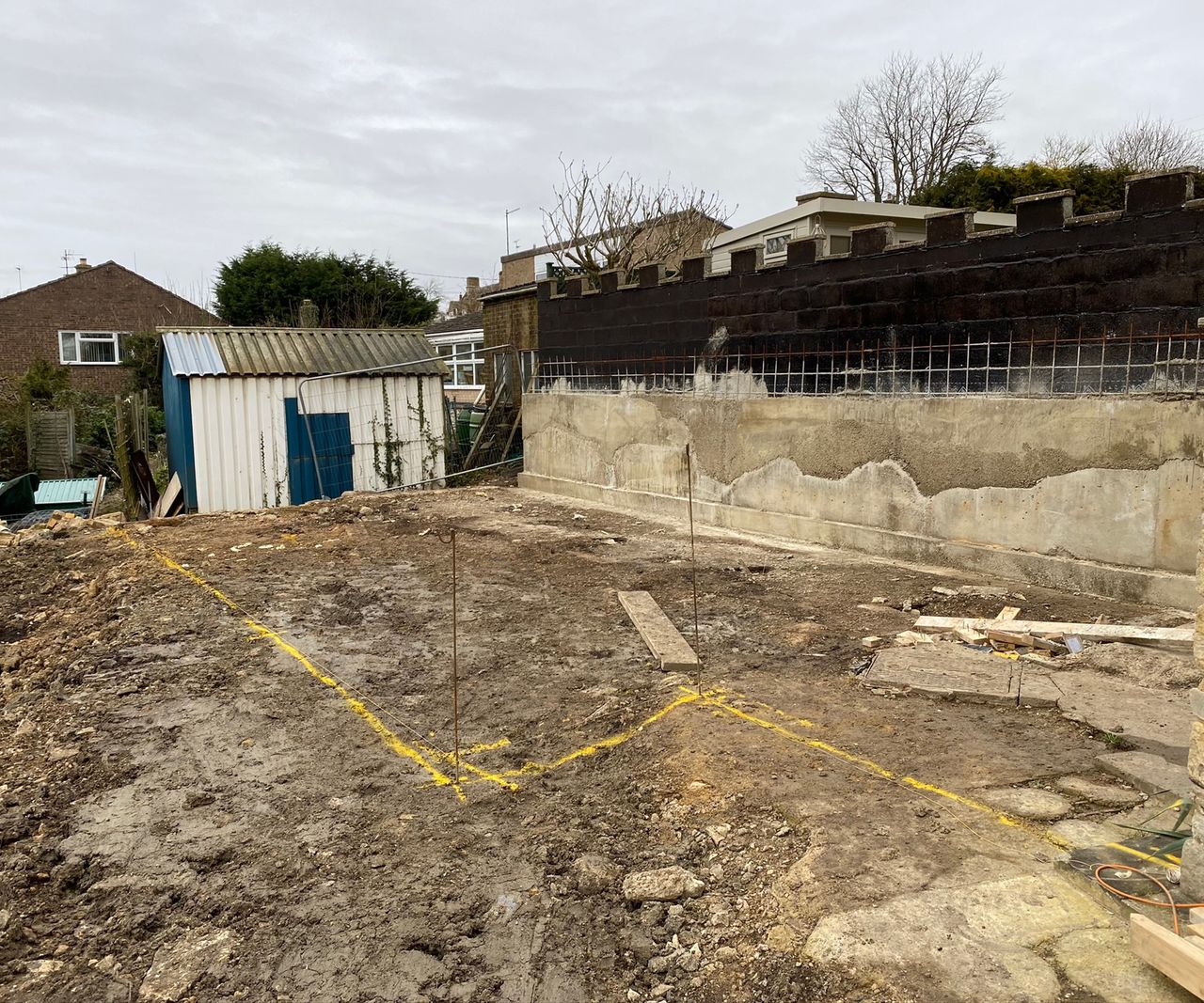 Shot of a demolished outbuilding with ground being marked out for an extension